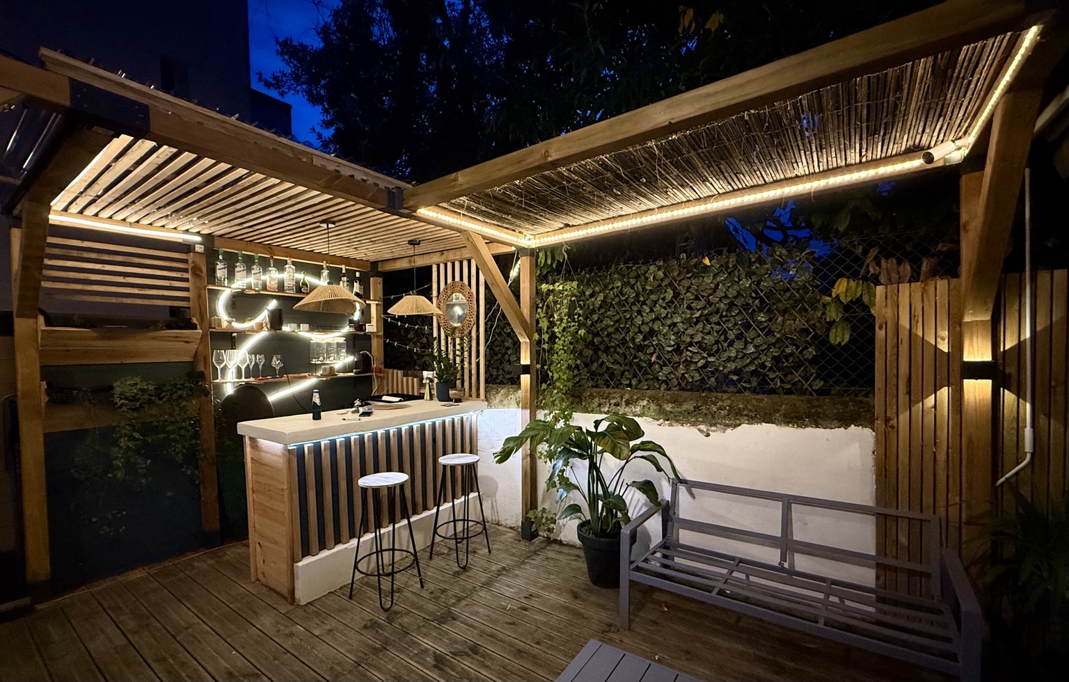Pergola et bar extérieur en bois éclairés de nuit